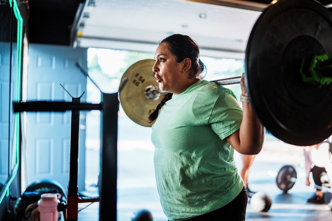 Kvinna tränar knäböj med skivstång i ett gym