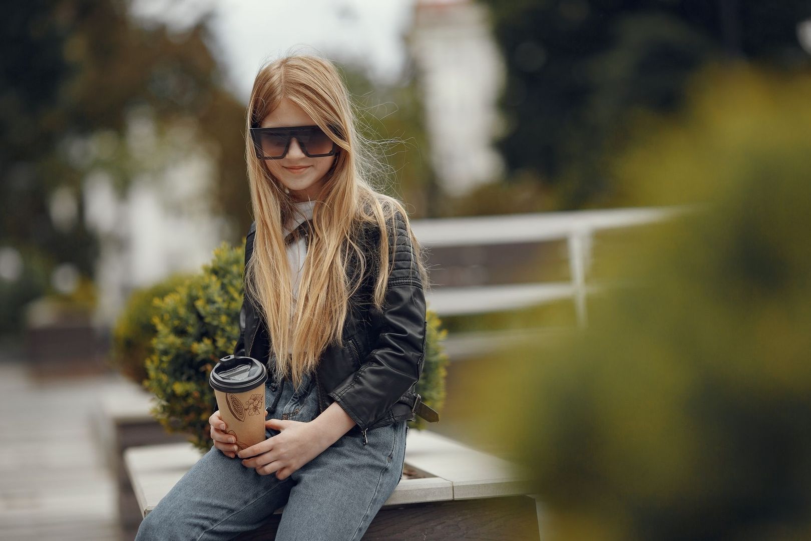 Ung kvinna i solglasögon tar en kaffepaus utomhus